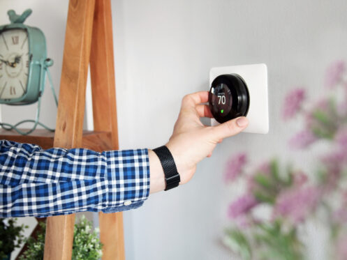 Homeowner adjusting smart thermostat